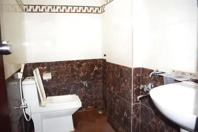 a bathroom with a toilet and a sink at SAK Royal Residency 1 km from Railway Station in Mysore