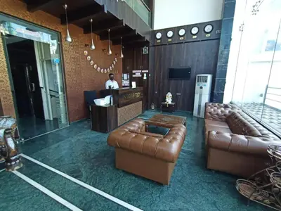 a lobby with two brown leather couches and a bar at SAK Royal Residency 1 km from Railway Station in Mysore