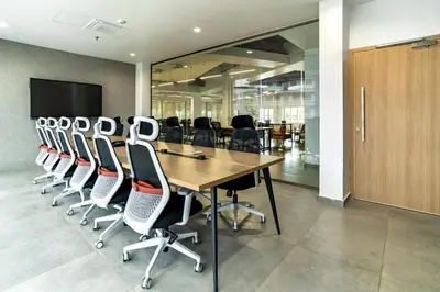 a conference room with a long wooden table and chairs at ESPERO INN Malappuram in Malappuram