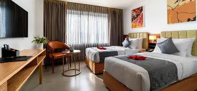 a hotel room with two beds and a desk at ESPERO INN Malappuram in Malappuram