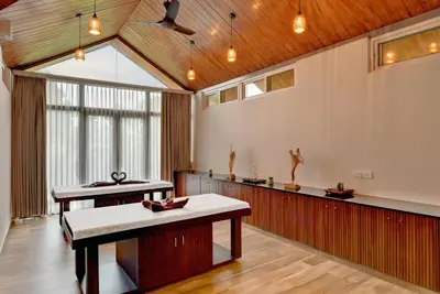 a large room with two tables and a large window at Sandesh Water Edge Kabini in Begūr