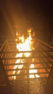 a fire in a wooden frame with flames at Rosewood 1 in Ooty