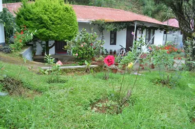 a small white house with flowers in the yard at Rheinberg Town Haus in Munnar