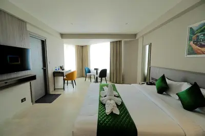 a hotel room with a large bed and a desk at Mount Land in Sultan Bathery