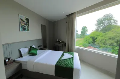 a bedroom with a bed and a large window at Mount Land in Sultan Bathery