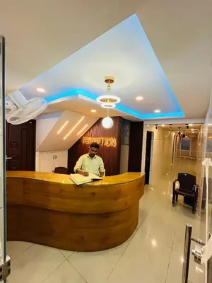 a man sitting at a bar in a lobby at Priya lodge in Kozhikode