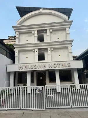 a white building with a welcome hotel sign on it at Welcome Hotels in Trichūr