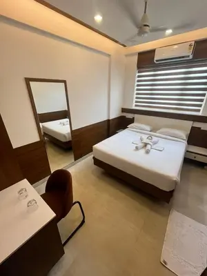 a hotel room with two beds and a mirror at Welcome Hotels in Trichūr