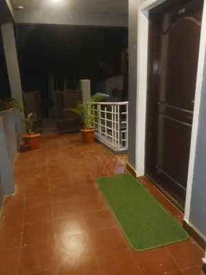 a living room with a green mat on the floor at Coorg Sunway home stay in Madikeri