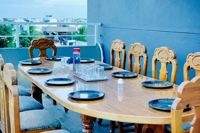 a wooden table with chairs and plates on it at Elite Enclave - Tellus - 2BHK - Luxury Serviced Apartments in Mysore