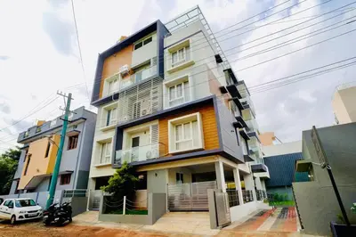 a building with a car parked in front of it at Elite Enclave - Spark - 2BHK Luxury Serviced Apartment in Mysore