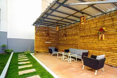 a patio with chairs and a table and a wooden wall at Elite Enclave - Spark - 2BHK Luxury Serviced Apartment in Mysore