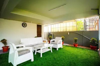 a patio with white chairs and a table and grass at Elite Enclave - Vento - 2BHK Luxury Serviced Apartments in Mysore