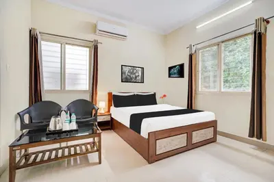 a hotel room with a bed and a desk at Super Townhouse Hebbal Mysore in Mysore