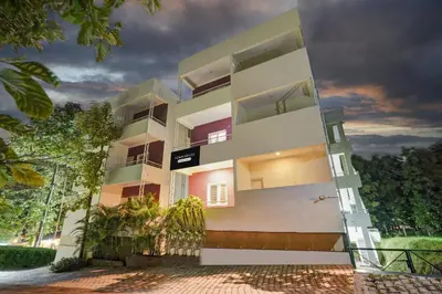 a white building with a door in front of it at Super Townhouse Hebbal Mysore in Mysore