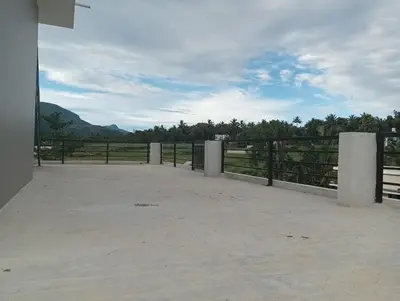 a patio with a fence and a view of a field at Bro Code Marayoor A Premium Family Friendly Retreat with Panoramic Mountain Views in Marayoor
