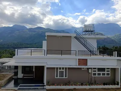 a white building with a staircase on top of it at Bro Code Marayoor A Premium Family Friendly Retreat with Panoramic Mountain Views in Marayoor