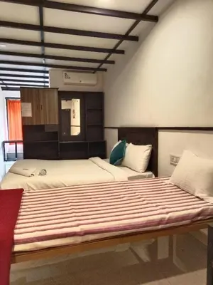a bedroom with two beds at JUNGLE VALLEY AYURVEDIC SPa RESORT in Meppādi
