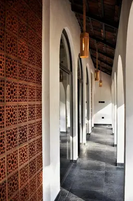 a hallway in a building with arches and a wall at Thira Beach Home in Thanniyam