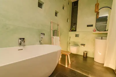 a bathroom with a white tub and a toilet at Thira Beach Home in Thanniyam