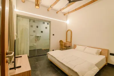 a bedroom with a bed and a glass shower at Thira Beach Home in Thanniyam