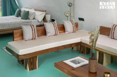 a living room with two benches and a table at StayVista at Shwaas 4BR Mysore with Private pool and landscape in Mysore