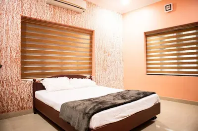a bedroom with a bed and a window with blinds at Jaalakam Retreat in Trichūr