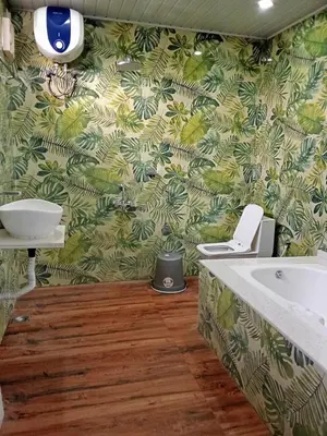 a bathroom with a toilet and a sink and a wallpaper at M Grand Stay in Coimbatore