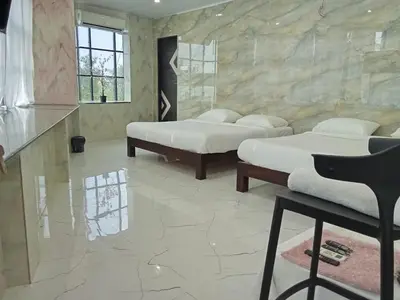 three beds in a room with a stone wall at M Grand Stay in Coimbatore