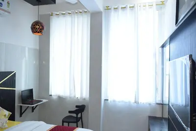 a bedroom with a bed and a desk and a window at M Grand Stay in Coimbatore