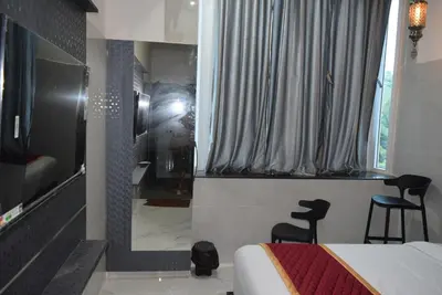 a bedroom with a bed and a window and two chairs at M Grand Stay in Coimbatore