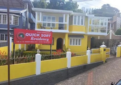 a yellow house with a sign in front of it at Quick Sort Residency in Ooty
