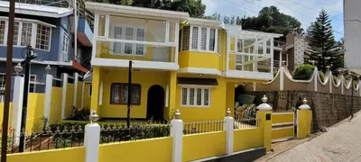 a yellow house with a fence in front of it at Quick Sort Residency in Ooty