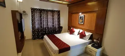 a bedroom with a bed with a wooden headboard at Quick Sort Residency in Ooty