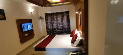 a bedroom with a bed and a television in it at Quick Sort Residency in Ooty