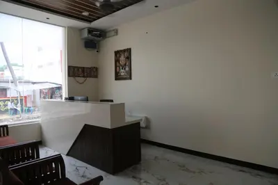 a white counter in a room with chairs at Kandhaguru Residency in Palani