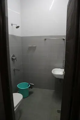 a bathroom with a toilet and a sink at Kandhaguru Residency in Palani