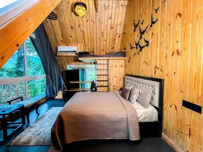a bedroom with a bed in a room with wooden walls at The Cove Lakkidi in Vythiri