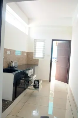 a kitchen with a sink and a counter top at Amma Inn Elegance Suites and Apartments in Mysore
