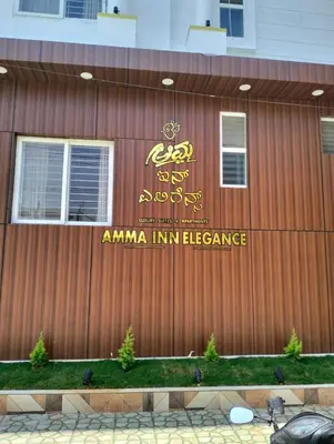 a building with a sign on the side of it at Amma Inn Elegance Suites and Apartments in Mysore