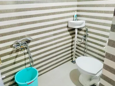 a bathroom with a toilet and a sink at Teyt's White Home - 3 bedroom Villa in Ooty