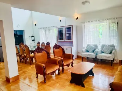 a room with a bunch of chairs and a table at Teyt's White Home - 3 bedroom Villa in Ooty