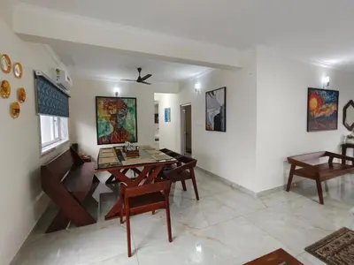 a living room with a wooden table and chairs at 7 Elysee Homestay - Onyx - Premium 3BHK Family Flat in Trichūr