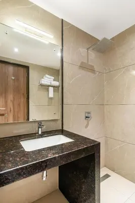 a bathroom with a sink and a mirror at Royal Embassy in Erode