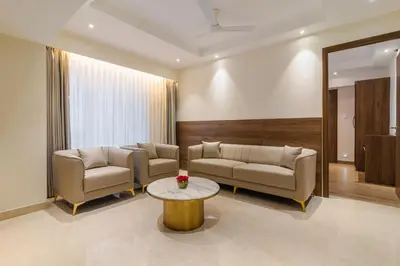 a living room with two couches and a table at Royal Embassy in Erode