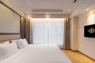 a bedroom with a large white bed and a window at Royal Embassy in Erode