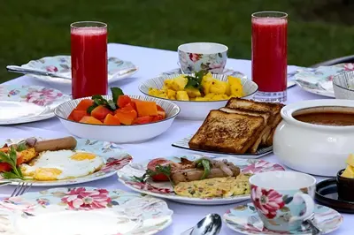 a table with plates of food and cups of coffee at Wildside Wayanad in Wayanad