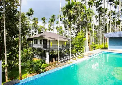 a villa with a swimming pool and a house at Wildside Wayanad in Wayanad