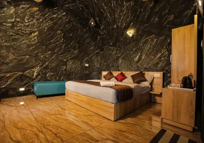 a bedroom with a bed and a stone wall at Wildside Wayanad in Wayanad
