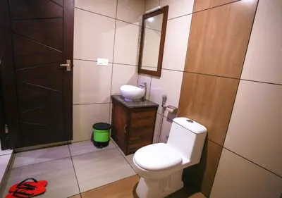 a bathroom with a toilet and a sink and a mirror at Wildside Wayanad in Wayanad